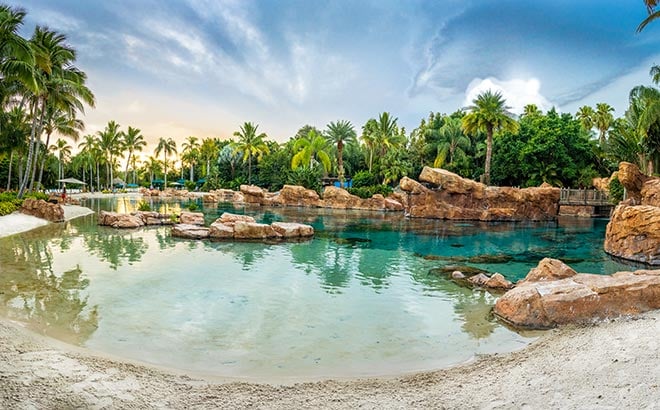 cove of water surrounded by rocks, trees and beach
